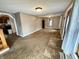 Open living room with carpet and neutral paint, leading to the kitchen at 710 Bacon St, Indianapolis, IN 46227