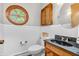 Bathroom features a round window, black granite countertop, wooden cabinetry and half wall paneling at 7380 N State Road 267, Brownsburg, IN 46112