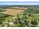 A serene aerial view of a neighborhood with lush greenery, interspersed homes, and adjacent open fields under a bright sky at 7426 N Carroll Rd, Indianapolis, IN 46236