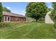 Spacious backyard featuring a lush lawn, a beautiful deck, and a storage shed, perfect for outdoor activities and relaxation at 7426 N Carroll Rd, Indianapolis, IN 46236