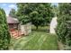 Lush backyard featuring a shed, mature trees, and a wooden deck, offering a serene outdoor retreat at 7426 N Carroll Rd, Indianapolis, IN 46236