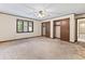 Spacious bedroom with neutral carpet, trim, closet, and an open doorway to the rest of the home at 7426 N Carroll Rd, Indianapolis, IN 46236