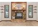 Beautiful stone fireplace with wooden mantel, flanked by windows and floating shelves, creating a cozy focal point in the room at 7426 N Carroll Rd, Indianapolis, IN 46236