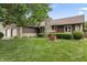 Charming home featuring a stone chimney, well-manicured lawn, and attractive landscaping at 7426 N Carroll Rd, Indianapolis, IN 46236