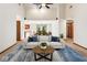 Living room showcasing a modern sofa, plants, blue carpet, and an open layout with kitchen view at 7426 N Carroll Rd, Indianapolis, IN 46236