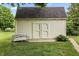 Backyard outbuilding shed with double doors and bench, perfect for storage and relaxation at 7426 N Carroll Rd, Indianapolis, IN 46236