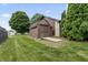 Backyard shed with a wooden ramp, nestled on a manicured lawn with mature trees, offering practical outdoor storage at 7426 N Carroll Rd, Indianapolis, IN 46236
