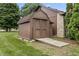 An outdoor storage shed with a wooden ramp and a nearby stone chimney at 7426 N Carroll Rd, Indianapolis, IN 46236