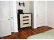 Bedroom featuring wood floors, a dresser with a typewriter on top, and two white doors at 7443 Country Brook Dr, Indianapolis, IN 46260