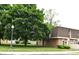 Exterior view of a brick building with lush greenery and a well-maintained lawn at 7443 Country Brook Dr, Indianapolis, IN 46260