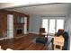 Spacious living room featuring a brick fireplace, wood floors, and ample natural light at 7443 Country Brook Dr, Indianapolis, IN 46260