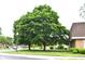 Street view of lush trees and a sidewalk beside a red brick building at 7443 Country Brook Dr, Indianapolis, IN 46260
