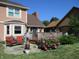 Charming backyard featuring a stone patio, deck, and colorful flower gardens, perfect for outdoor relaxation at 8331 Tequista Ct, Indianapolis, IN 46236