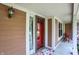 Inviting covered front porch featuring a vibrant red door, decorative lighting, and outdoor seating at 8331 Tequista Ct, Indianapolis, IN 46236