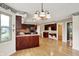 Open concept kitchen with dark wood cabinetry, hardwood floors and view of the dining area at 8331 Tequista Ct, Indianapolis, IN 46236