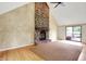 Open living room features a brick fireplace, vaulted ceiling, and sliding glass doors to the backyard at 8331 Tequista Ct, Indianapolis, IN 46236