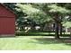 Expansive backyard featuring a playset, deck with seating, and a charming red outbuilding at 8373 W State Road 47, Thorntown, IN 46071