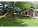 Spacious backyard with a playset and a deck featuring outdoor seating for relaxation and entertainment at 8373 W State Road 47, Thorntown, IN 46071