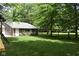 Well-maintained backyard with lush green grass and mature trees creating a serene outdoor space at 8373 W State Road 47, Thorntown, IN 46071
