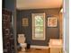 Neutral toned bathroom featuring a window, toilet, sink, framed artwork and decorative quote on the wall at 8373 W State Road 47, Thorntown, IN 46071