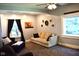 Cozy living room featuring neutral walls, plush carpet, comfortable seating, and natural light from the windows at 8373 W State Road 47, Thorntown, IN 46071