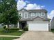 Two-story home featuring a two-car garage and well-maintained landscaping and gray siding at 842 Westpointe Dr, Shelbyville, IN 46176