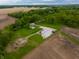 Aerial view of a home with a detached garage and a long driveway surrounded by trees and fields at 8468 S County Road 575 E, Mooresville, IN 46158