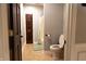 Bathroom featuring tile flooring, neutral wall paint, a wood door, a toilet, and a shower with blue curtain at 8468 S County Road 575 E, Mooresville, IN 46158