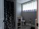 Bright bathroom with modern fixtures, includes window, toilet, shower with curtain, and storage at 8468 S County Road 575 E, Mooresville, IN 46158