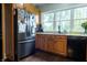 Bright kitchen featuring stainless steel refrigerator, ample cabinet space, and a window above the sink at 8468 S County Road 575 E, Mooresville, IN 46158