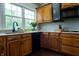 Cozy kitchen with oak cabinets, granite countertops, black appliances, and a large window for natural light at 8468 S County Road 575 E, Mooresville, IN 46158