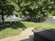 Lush backyard featuring mature trees, string lights, and a brick patio at 912 Delray Dr, Indianapolis, IN 46241