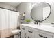 Bright bathroom featuring a modern vanity with black hardware and a round mirror at 912 Delray Dr, Indianapolis, IN 46241