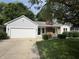 Charming home featuring a lush front lawn, attached garage, and brick chimney at 912 Delray Dr, Indianapolis, IN 46241