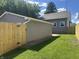 Backyard of a property showcasing a wooden privacy fence, a detached garage, and a well-maintained lawn at 920 E Tabor St, Indianapolis, IN 46203
