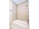Bright bathroom featuring a white tub and light gray tiled walls at 920 E Tabor St, Indianapolis, IN 46203