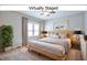 Staged bedroom featuring neutral colors, a ceiling fan, a large window and a minimalist decor at 920 E Tabor St, Indianapolis, IN 46203