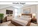 Staged bedroom featuring a bed, tv, and large window providing ample sunlight at 920 E Tabor St, Indianapolis, IN 46203