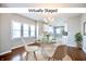 Virtually staged dining area featuring natural light, modern chandelier, and an open concept at 920 E Tabor St, Indianapolis, IN 46203