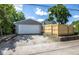 Detached garage with white door and adjacent parking pad providing ample parking space and additional storage at 920 E Tabor St, Indianapolis, IN 46203