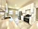 Bright kitchen featuring stainless steel appliances, white cabinetry, marble countertops, and tile floors at 920 E Tabor St, Indianapolis, IN 46203