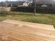 Backyard featuring a wooden deck with grass, a privacy fence, and mature trees at 1045 Springway Dr, Shelbyville, IN 46176