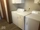 Laundry room with white washer and dryer, storage cabinet and vinyl plank flooring at 1045 Springway Dr, Shelbyville, IN 46176