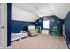 Cozy bedroom with navy walls, a vaulted ceiling, and a comfortable single bed and recliner at 11720 S County Road 396 E, Muncie, IN 47302