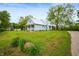 Quaint blue home showcasing a lush green lawn and a long driveway leading up to the house at 11720 S County Road 396 E, Muncie, IN 47302