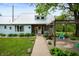Charming exterior view showcasing the lush front lawn, stone pathway, and lovely front entrance at 11720 S County Road 396 E, Muncie, IN 47302