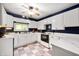 Bright kitchen with white cabinetry, contrasting navy walls, and a ceiling fan at 11720 S County Road 396 E, Muncie, IN 47302