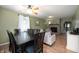 Open-concept living and dining areas featuring a stone fireplace, ceiling fan, and light green paint at 11720 S County Road 396 E, Muncie, IN 47302