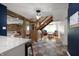 Open-concept living space with wood beam accents and staircase adjacent to a playroom at 11720 S County Road 396 E, Muncie, IN 47302