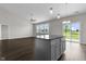 Modern, open-concept kitchen with hardwood floors, an island, and a door to the backyard at 11815 Adair Pl, Indianapolis, IN 46229